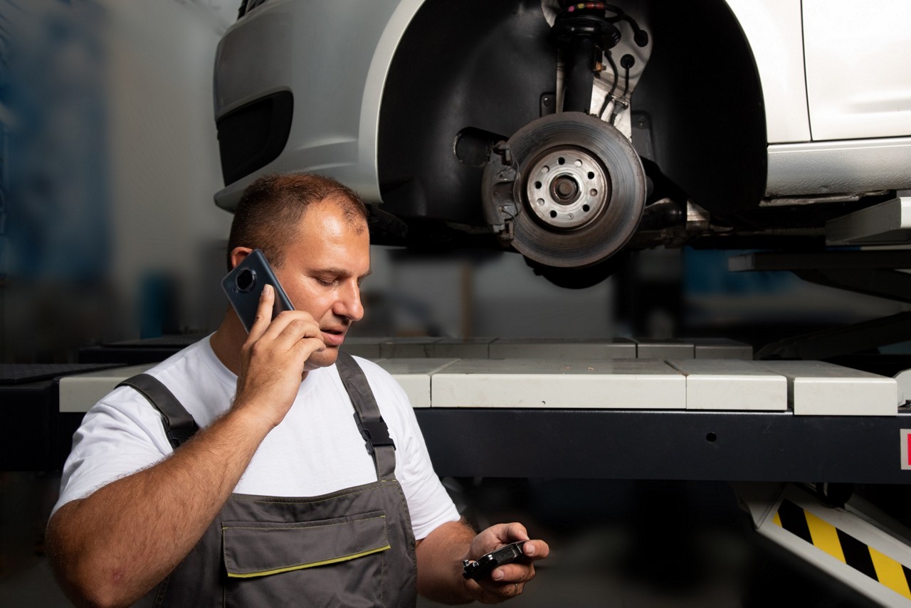 Mechanik Garage Gurus řeší technický telefonát v autoservisu