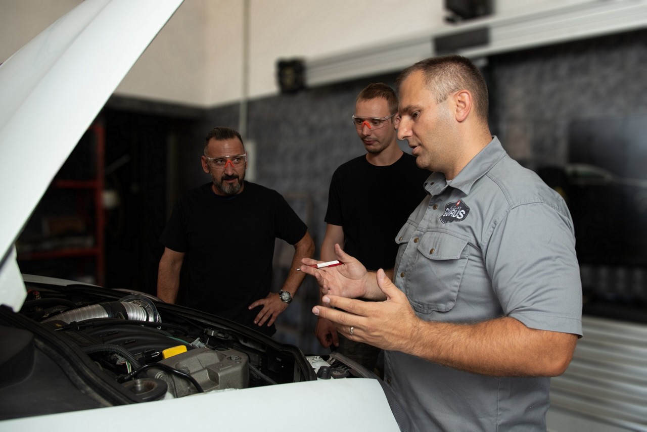 Garage Gurus donnant une formation sur les moteurs à des mécaniciens dans un garage. 