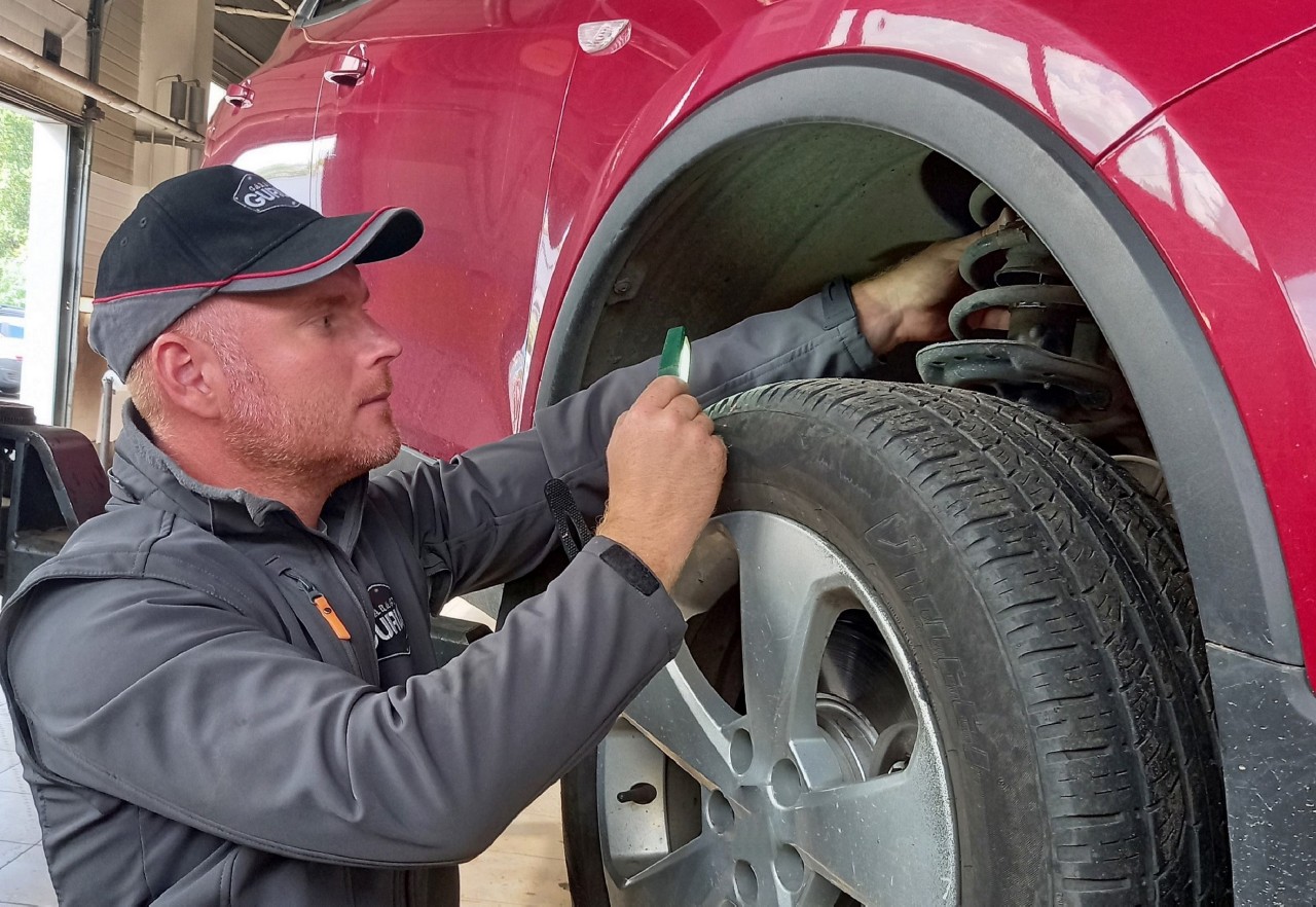 technicien effectuant un diagnostic des pièces de suspension